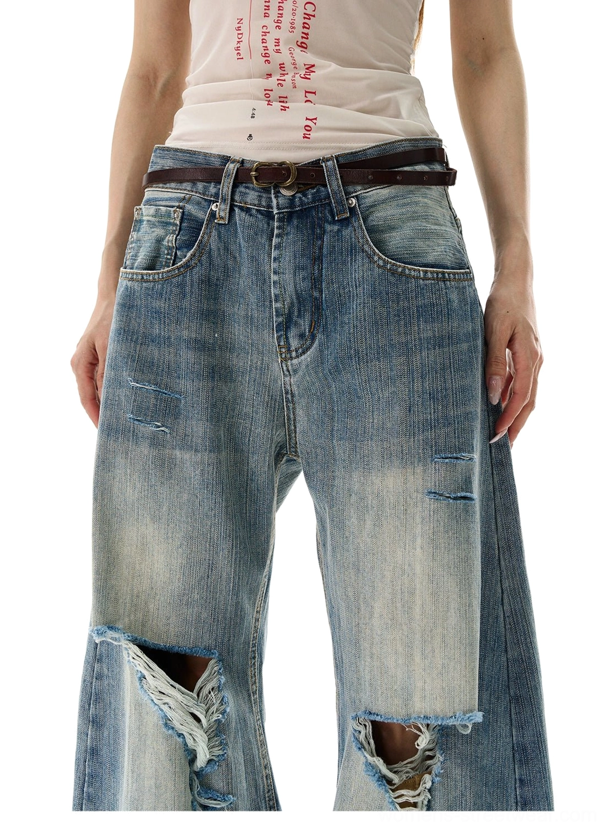Close front view of blue hole distressed wide leg jeans with large ripped knees and faded wash