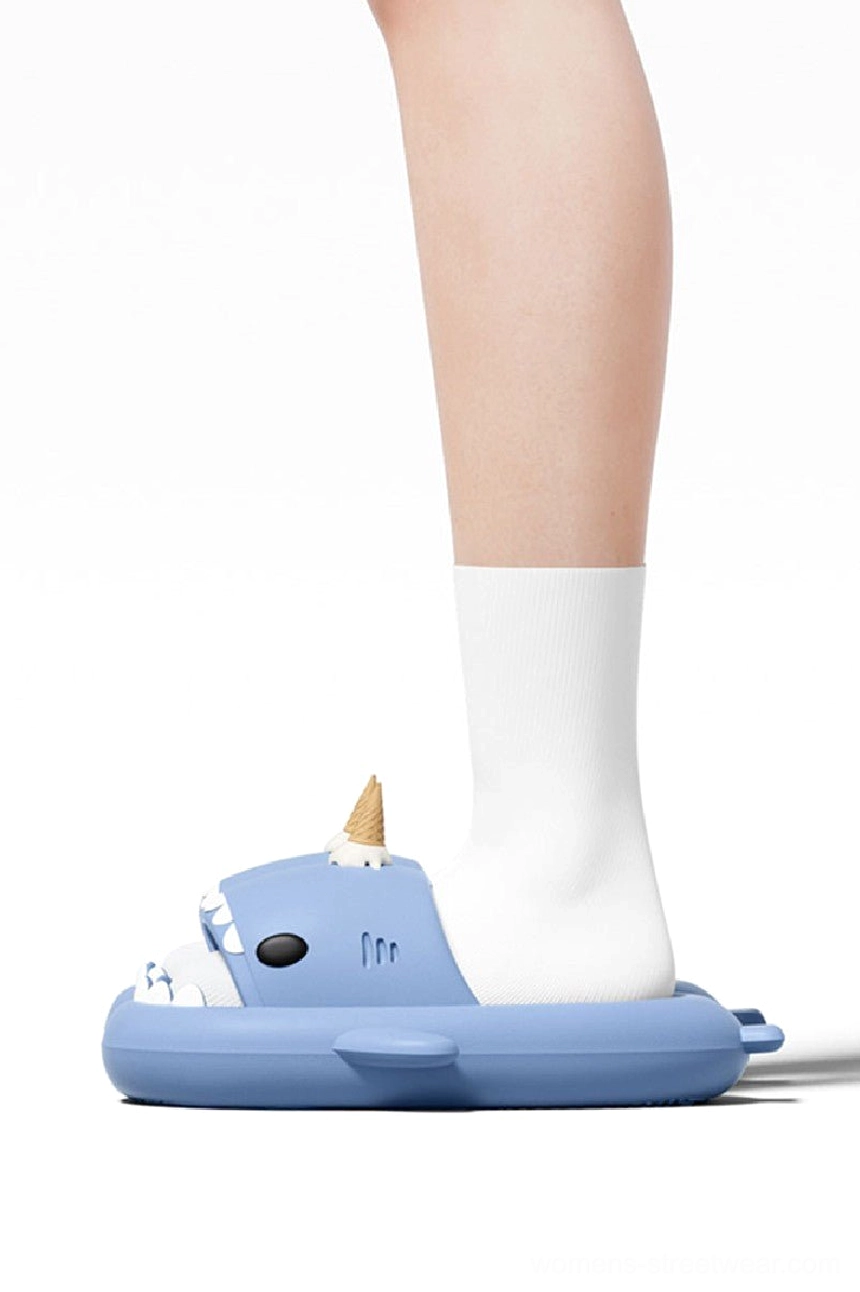 Person wearing blue ice cream shark slide slippers with white socks showing comfortable everyday fit