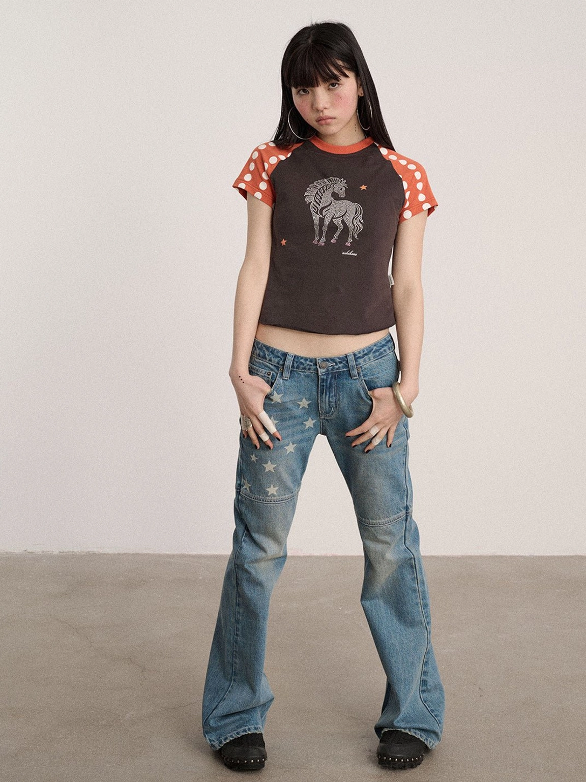 Blue low-rise flare jeans with star panel graphics, retro Y2K denim styling, structured seams, and a clean bootcut finish