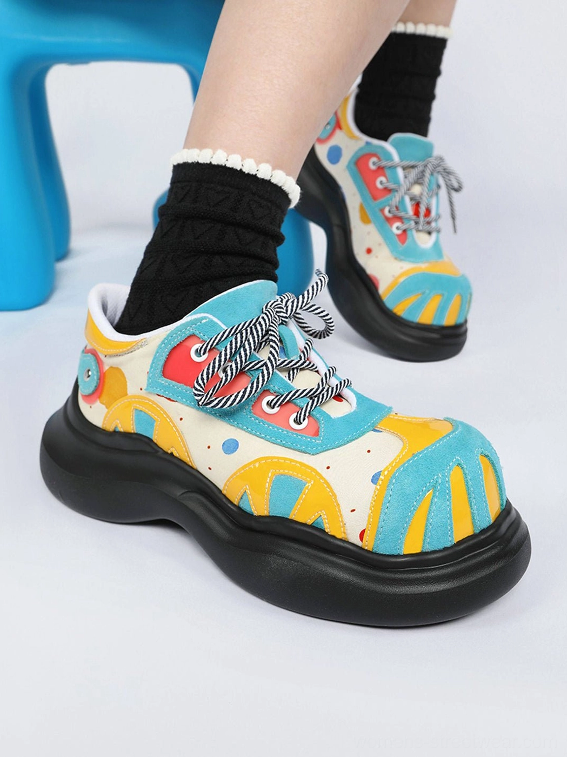 Front view of blue multicolor graphic platform derby shoes with striped laces and thick black soles