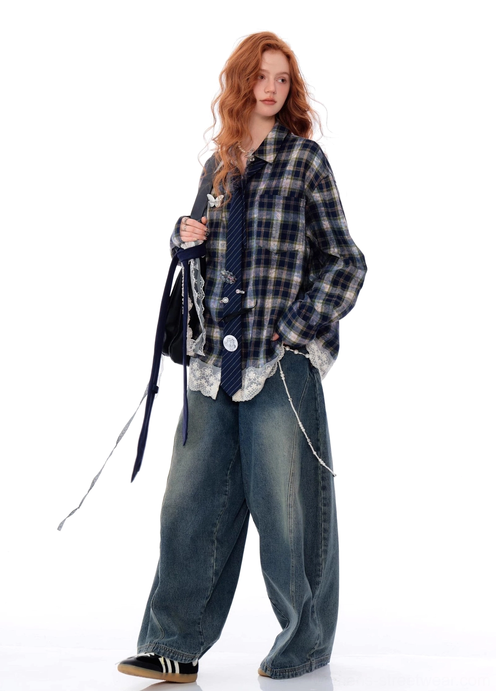 Side profile of a blue plaid lace hem button-up shirt styled with casual sneakers and a chain shoulder bag