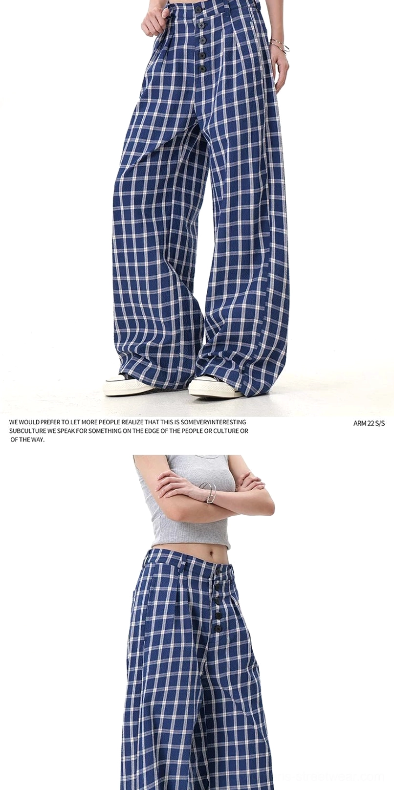 Close lower-body view of blue plaid wide-leg streetwear pants showing high waist, button closure, and flowing leg