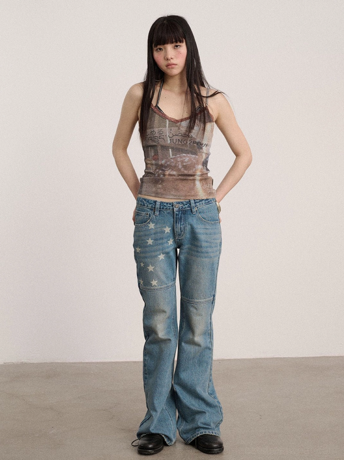 Blue star panel low-rise flare jeans styled as Y2K streetwear with a fitted upper leg and elongated flared denim silhouette