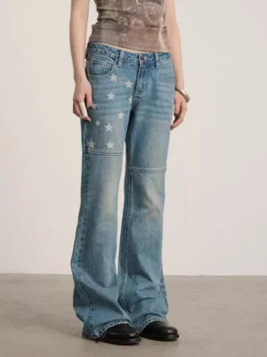 Side front view of low-waist blue star print flare jeans showing knee seam details, faded indigo denim, and flared legs