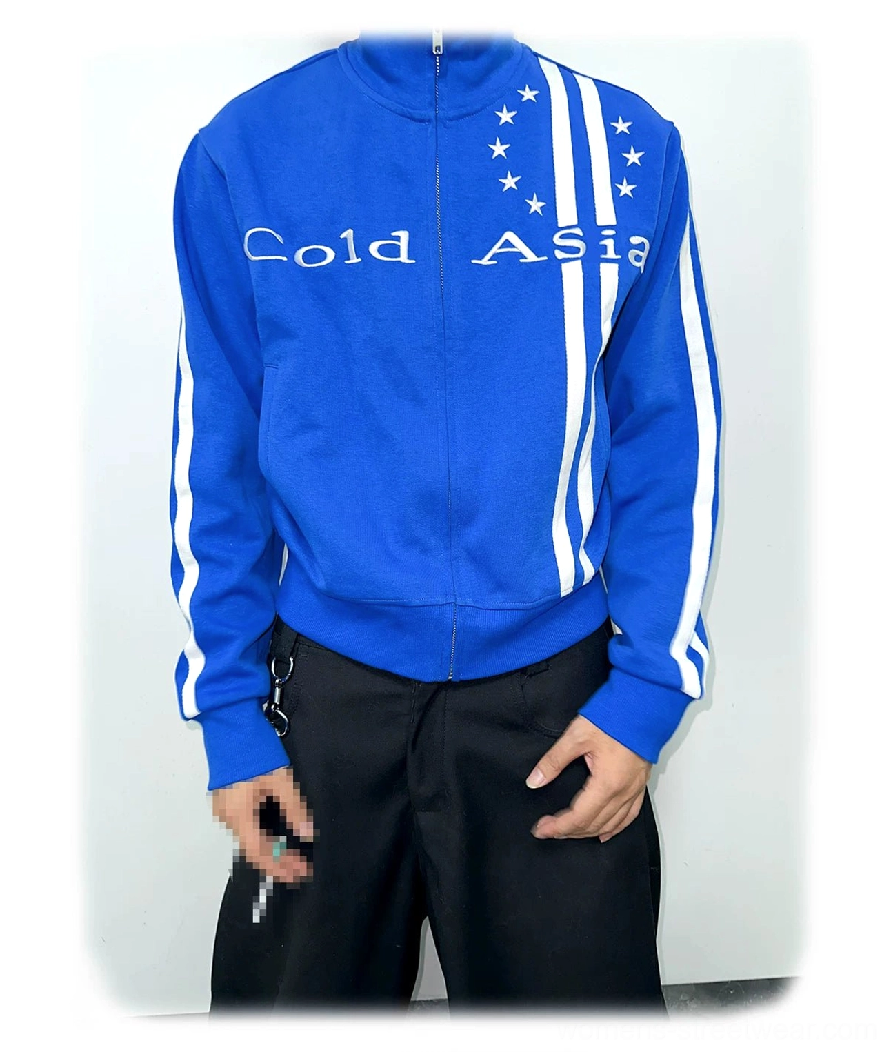 Front studio view of a royal blue starstripe track jacket with stand collar, full zipper, white sleeve stripes, graphic details, and ribbed hem