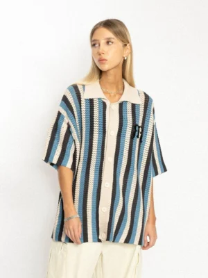Female model wearing a blue stripe openwork oversized polo shirt with cream loose pants in a relaxed Korean streetwear outfit
