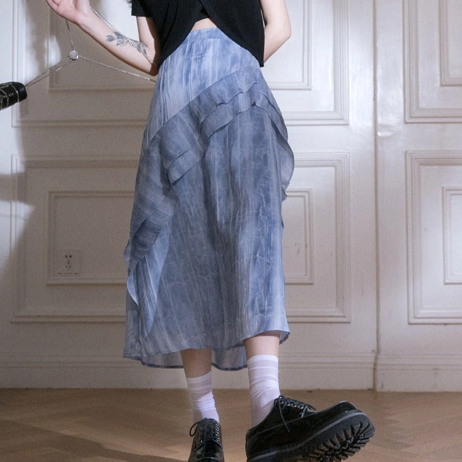 Back right full-body view of blue tie-dye ruffle cascade streetwear maxi skirt styled with white socks and black platform loafers