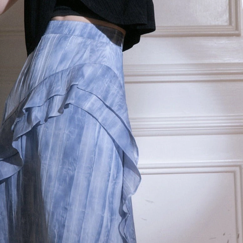Close-up of blue tie-dye ruffle cascade maxi skirt fabric with vertical watercolor stripes and layered ruffle trim