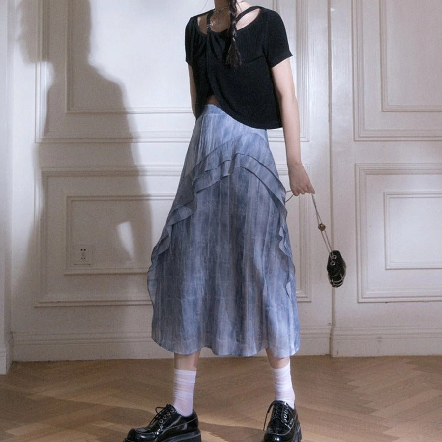 Blue tie-dye ruffle cascade streetwear maxi skirt in front three-quarter view styled with black cropped top and chain crossbody bag