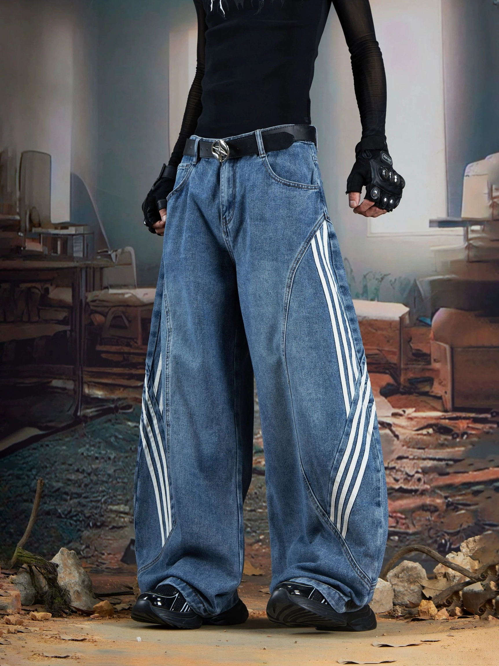 Close-up front view of blue washed balloon baggy jeans with white triple side stripes, curved seams, leather belt, and black streetwear shoes