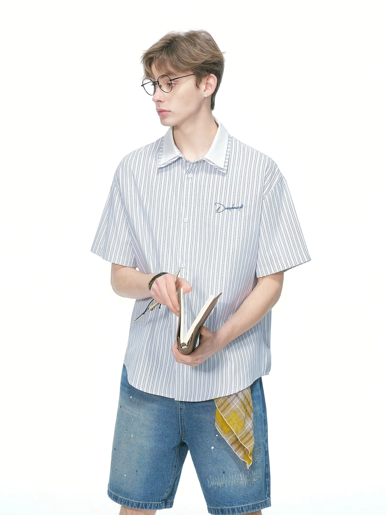 Blue and white relaxed pinstripe short sleeve shirt with classic contrast collar and embroidered chest detail shown from a side front angle