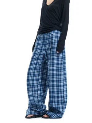 Side view of blue and white plaid wide-leg cotton pants with elastic waistband, relaxed full-length silhouette and black long-sleeve top