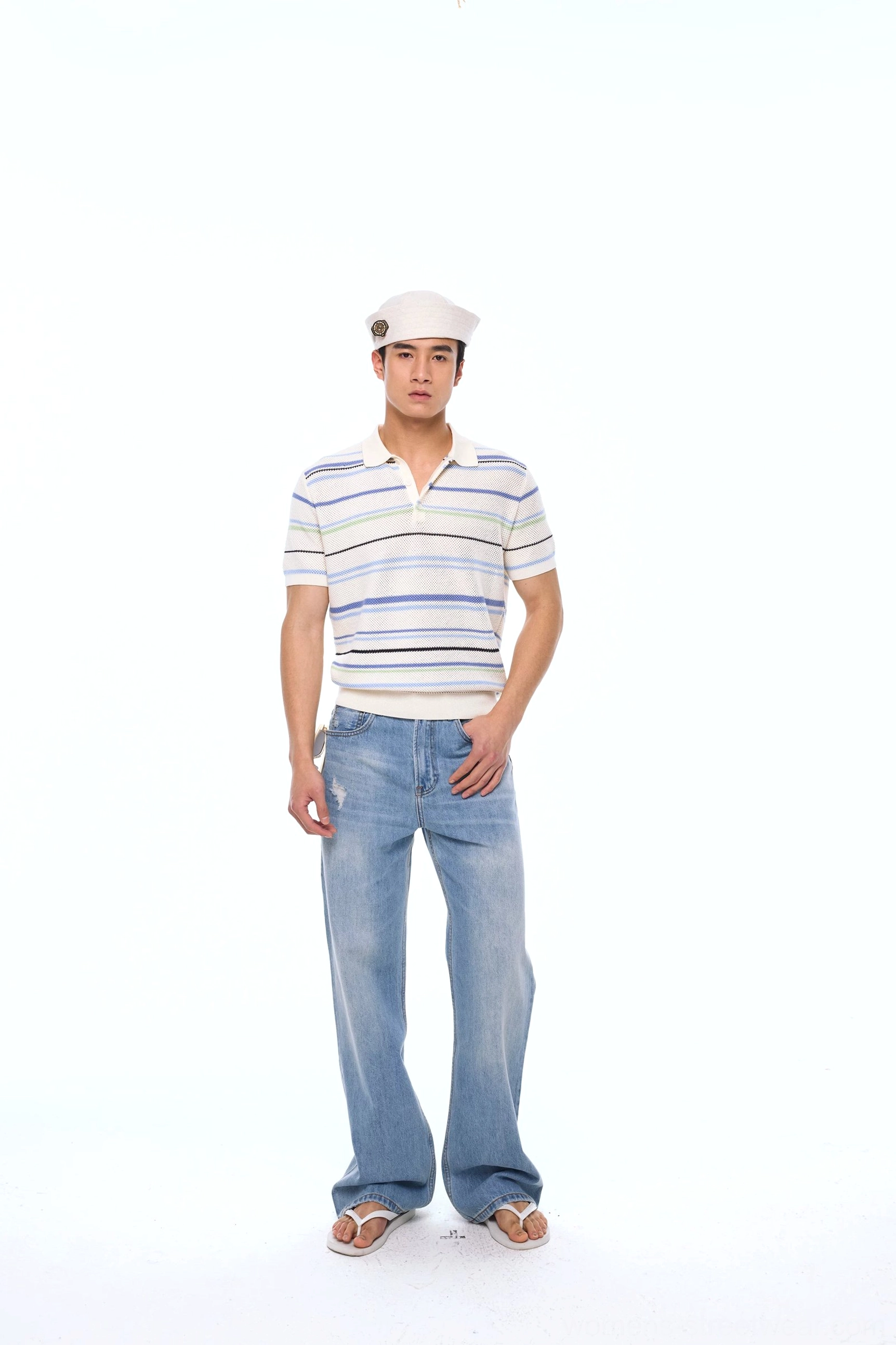 Full-body front view of a relaxed blue and white striped knit polo shirt with short sleeves styled with wide-leg blue jeans for casual Seoul streetwear