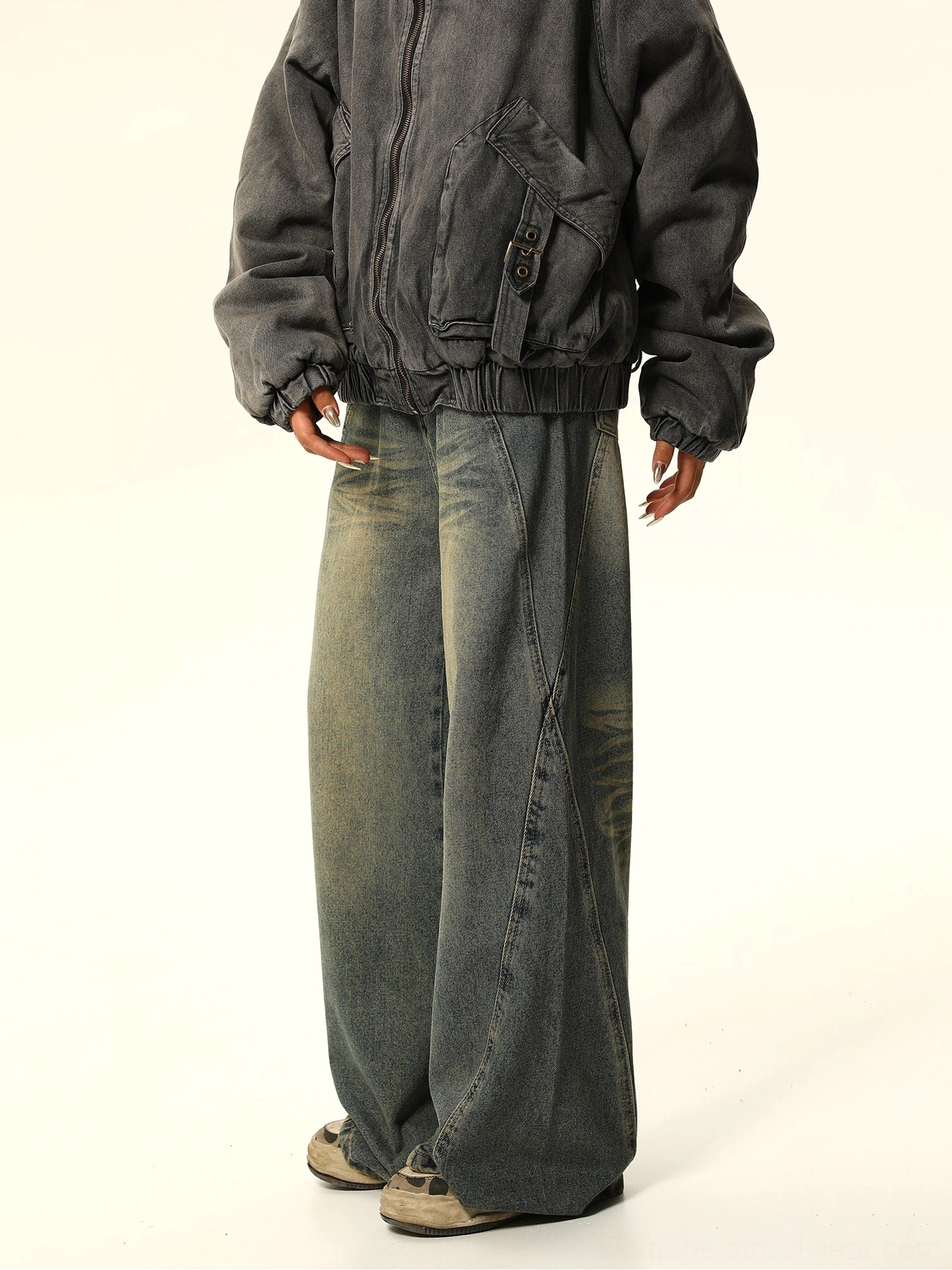 Three-quarter side view of blue wide-leg carpenter jeans showing curved side seams and utility pocket detail