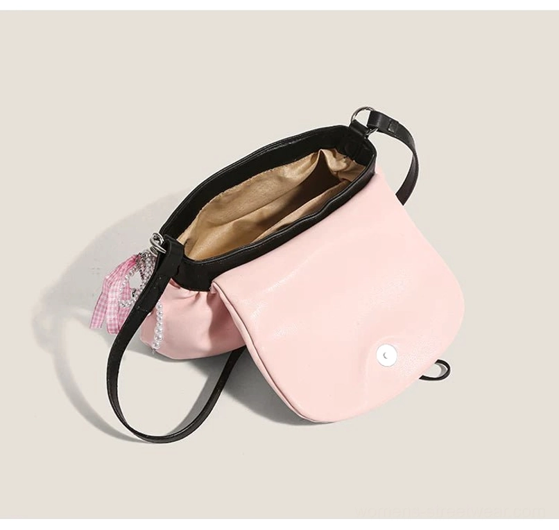 Interior of blush pink lace bow shoulder satchel showing brown polyester lining magnetic snap closure and inner compartment