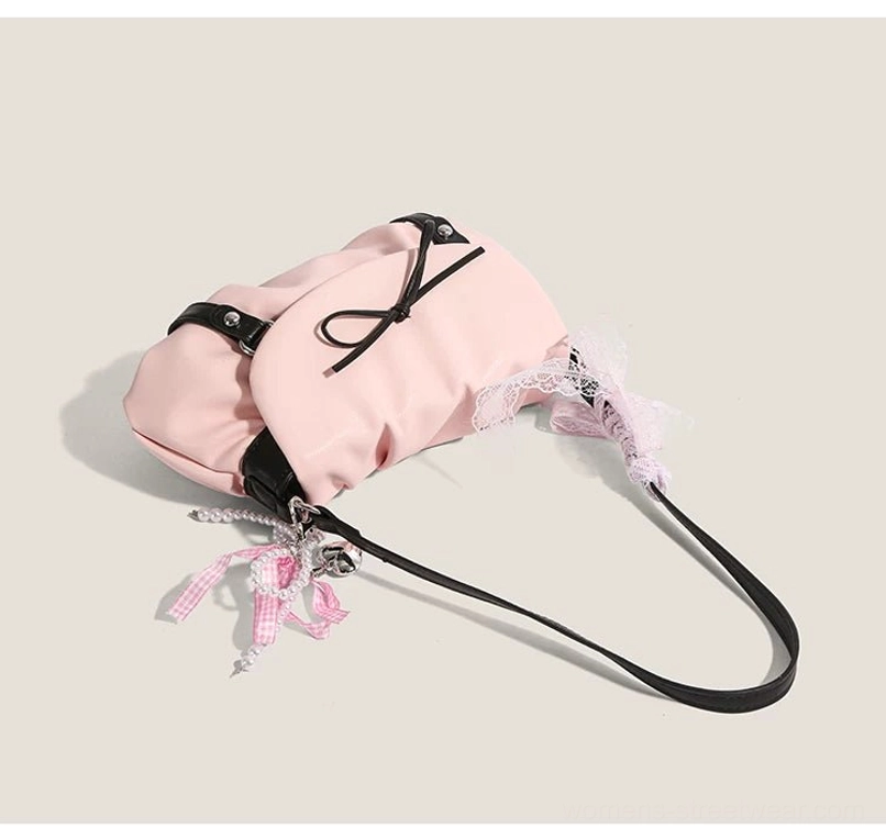 Pink lace bow ruched shoulder satchel flat lay showing long black crossbody strap lace trim and dual bow details