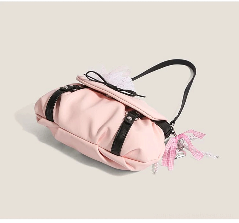 Pink lace bow crossbody satchel top oblique view with flap closure black straps and gingham ribbon tassel