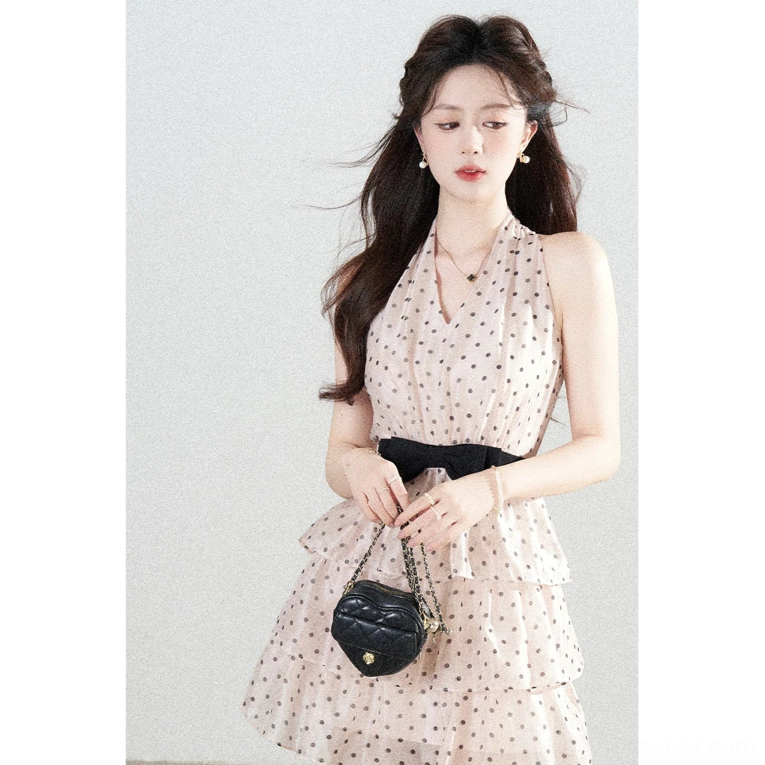 Blush pink polka dot bow halter mini dress full body front view with black bow waist detail