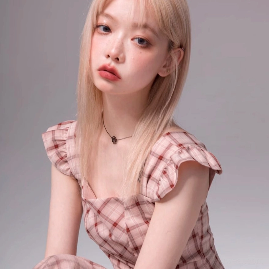 Close-up portrait of a blush plaid dress neckline with delicate ruffled sleeves and romantic streetwear styling