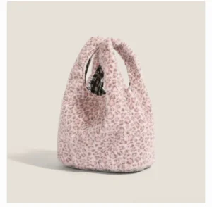 Rear three quarter view of blush snow leopard plush hobo tote bag showing slouchy silhouette and gingham interior
