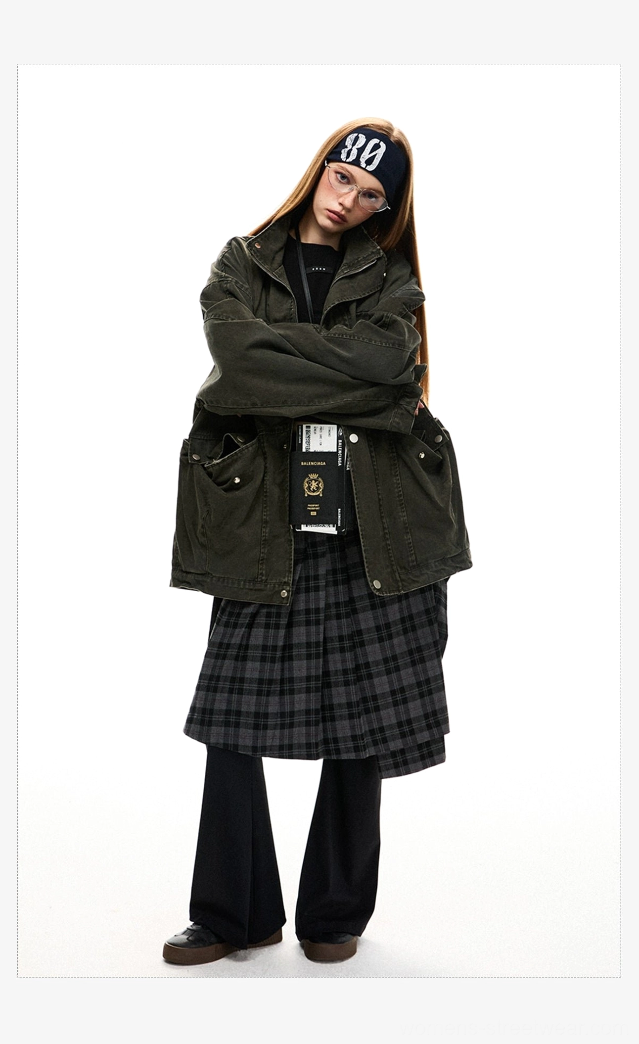Front view of a woman wearing a boxy oversized dark olive utility jacket with low-set cargo pockets and relaxed draped streetwear fit