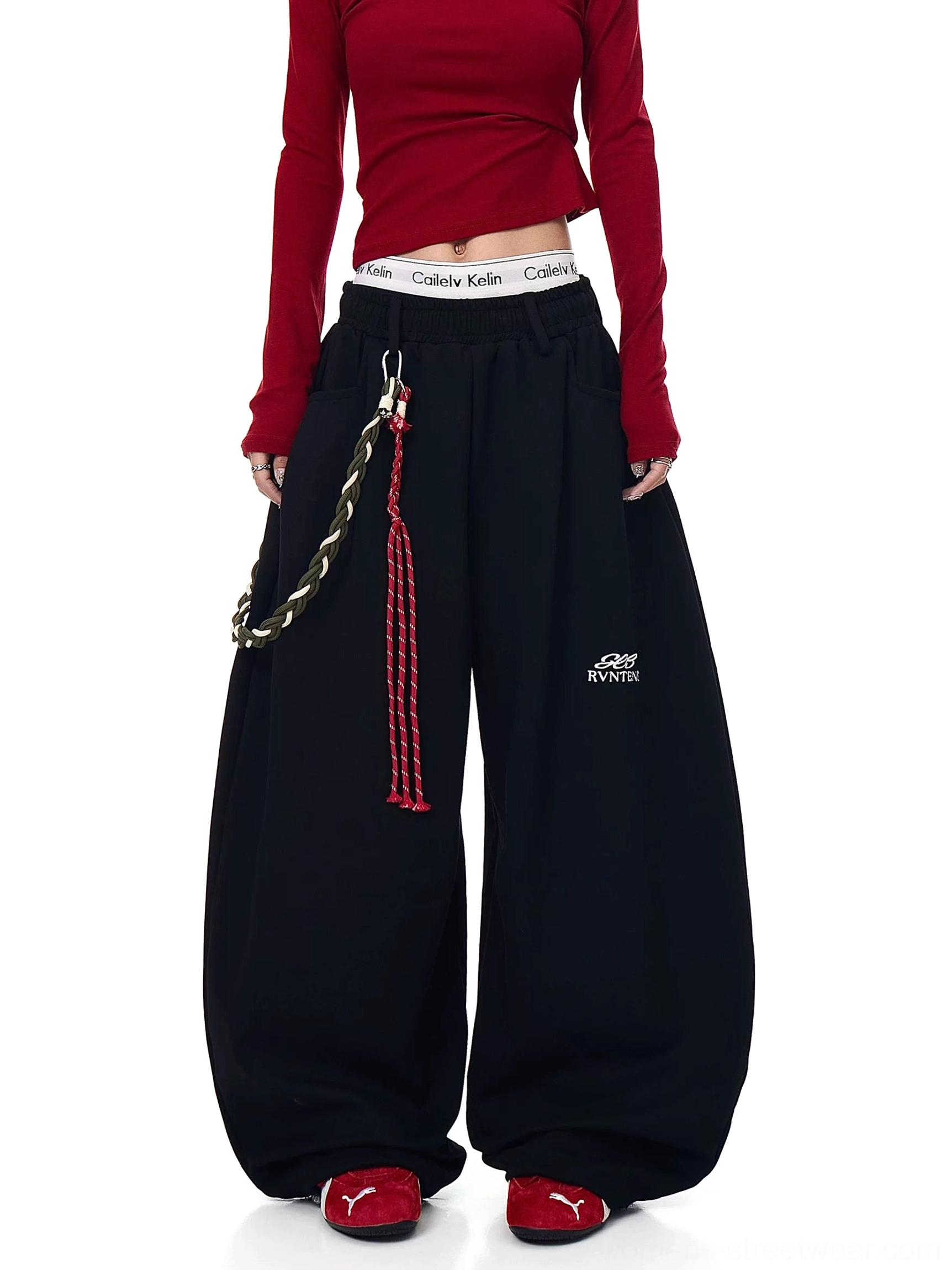 Black oversized wide-leg streetwear track pants with braided rope detail and puddle-stacked legs front studio view