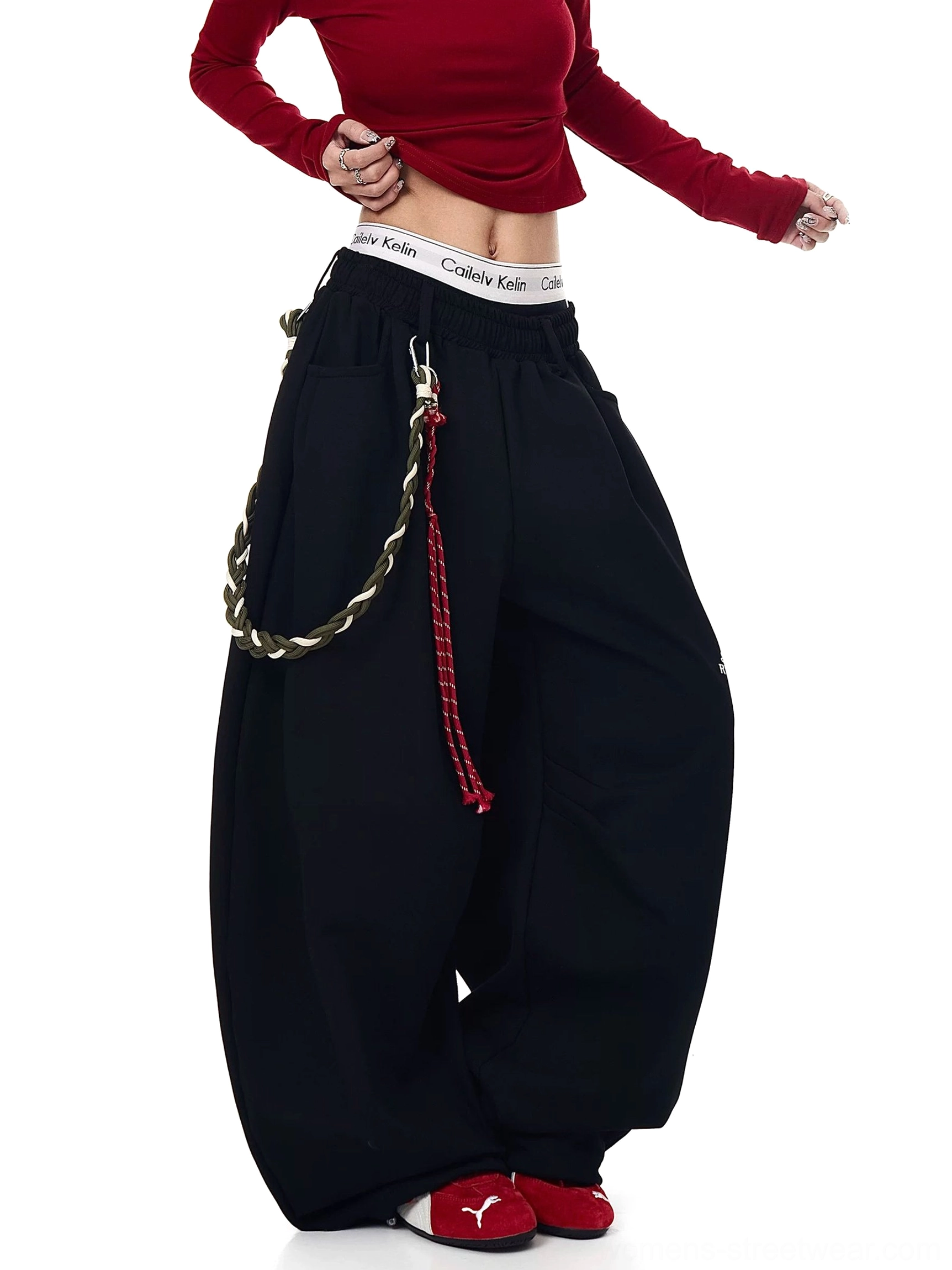 Black oversized wide-leg fleece streetwear track pants side view with braided rope accessory and stacked hem