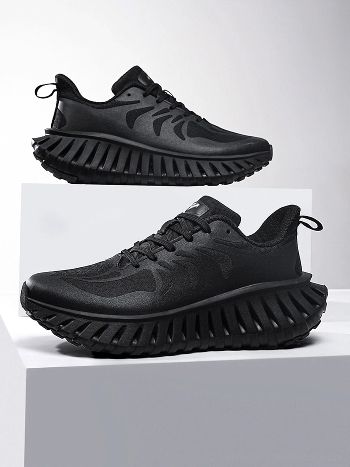 All-black breathable running sneakers displayed from side and front three-quarter angles with lace-up closure and rugged serrated sole
