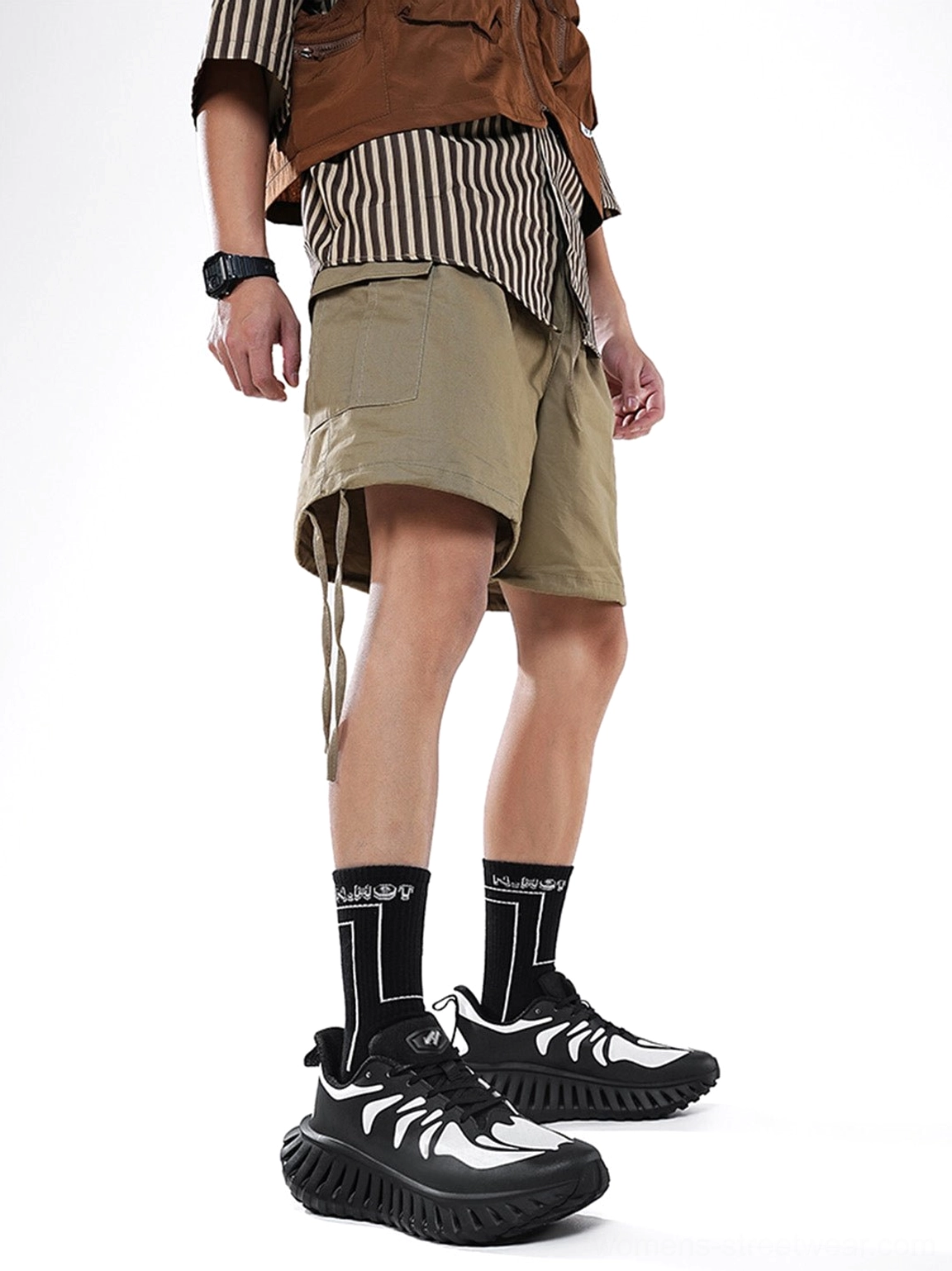 Black and white skeletal-style running sneakers shown on a standing model from a low front angle with a bold colorblock athletic profile