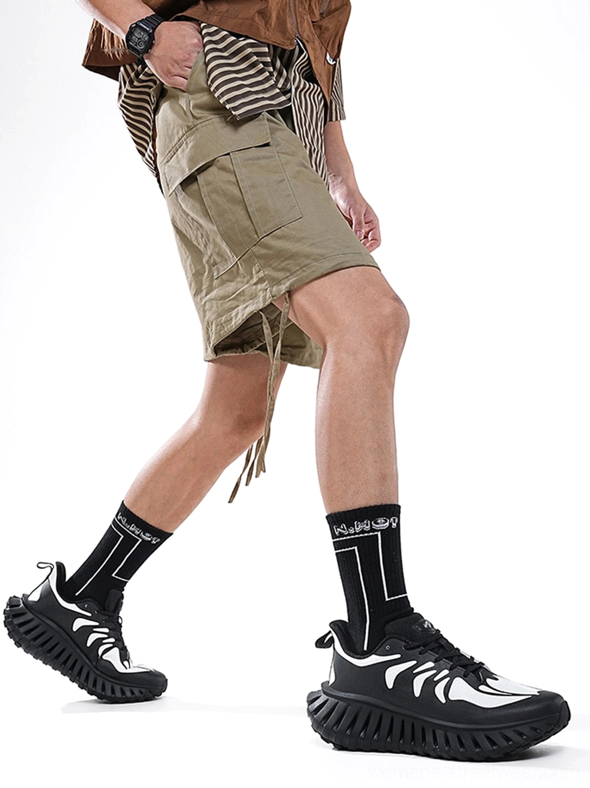 Colorblock running sneakers shown on a walking model, highlighting the layered side panels, low-top silhouette, and thick textured streetwear outsole