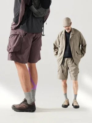 Relaxed breathable cargo shorts shown on male streetwear models with large multi-pocket utility design and loose gorpcore fit