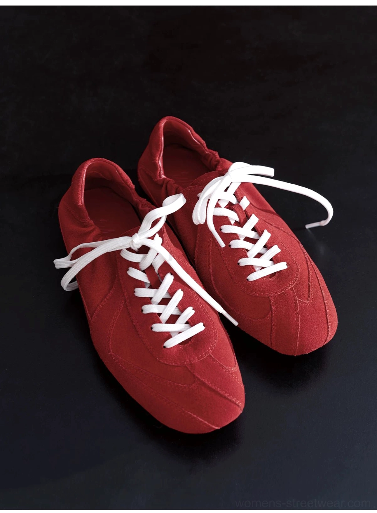 Bright red suede minimalist lace-up sneaker with crisp white flat laces and a rounded clean toe cap