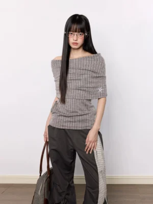 Brown asymmetric off-shoulder star embroidered pinstripe knit top styled with dark cargo pants in a front full-body streetwear outfit