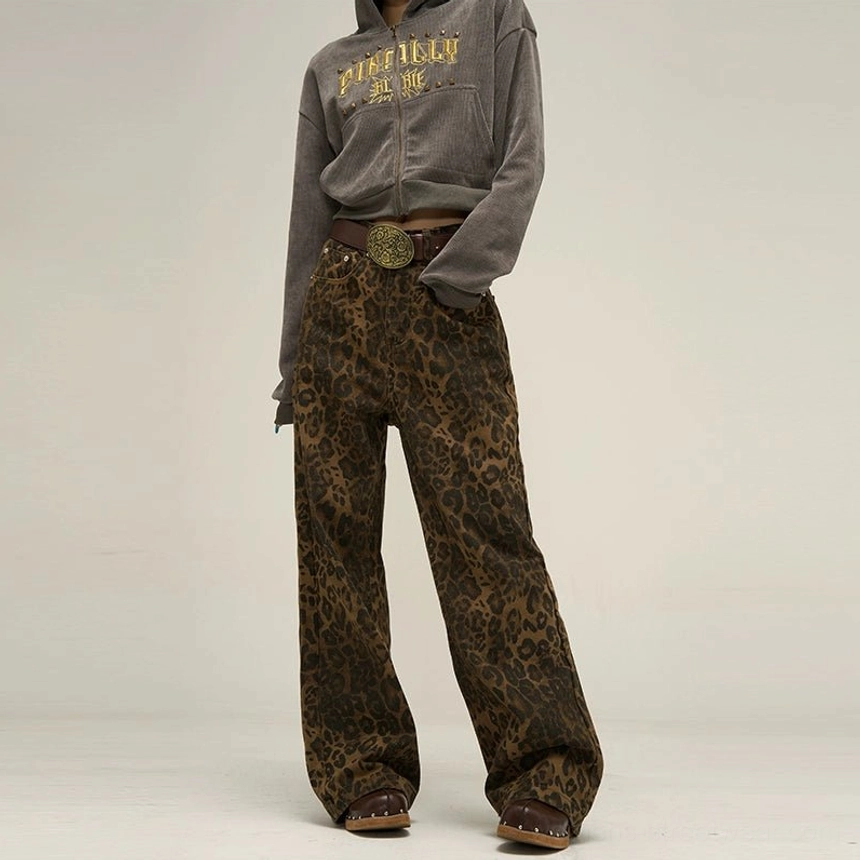 Full front view of brown and black leopard print wide leg streetwear pants styled with a grey hoodie, statement belt, and brown clogs