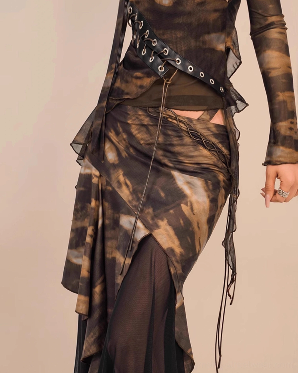 Detailed view of brown black abstract tie dye asymmetrical skirt showing grommet waist belt side drawstring sheer mesh slit and layered ruffled hem
