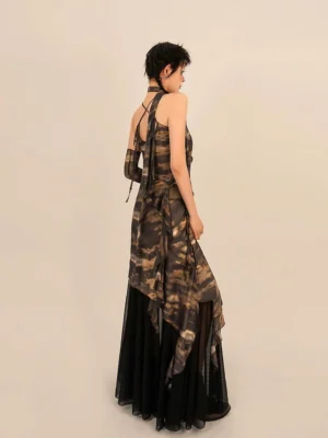 Back view of a brown black tie dye two piece streetwear outfit showing the halter camisole tie and flowing asymmetrical maxi skirt silhouette