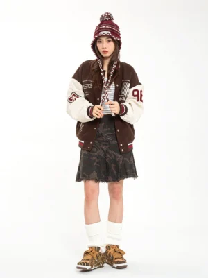 Female model styling brown camo chunky platform skate sneakers with varsity jacket and camo mini skirt