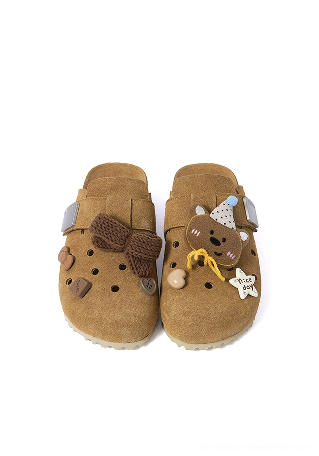 Front product view of brown charm-decorated perforated clogs featuring knit bows, button charms, star badges, and breathable uppers