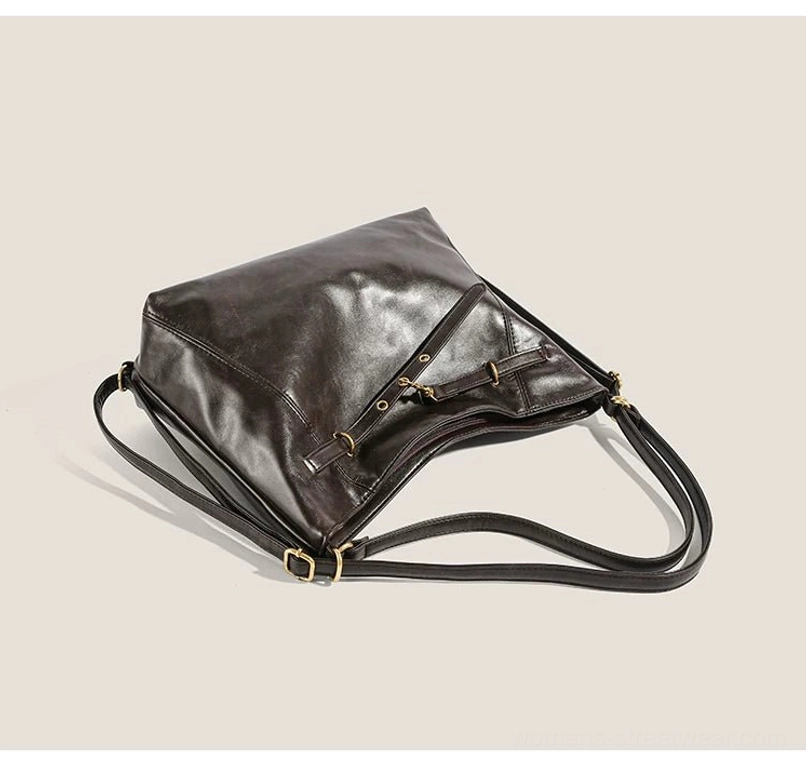 Dark brown convertible buckle hobo bag shown from the rear side with dual adjustable straps, gold-tone hardware, flat back panel, and versatile crossbody styling