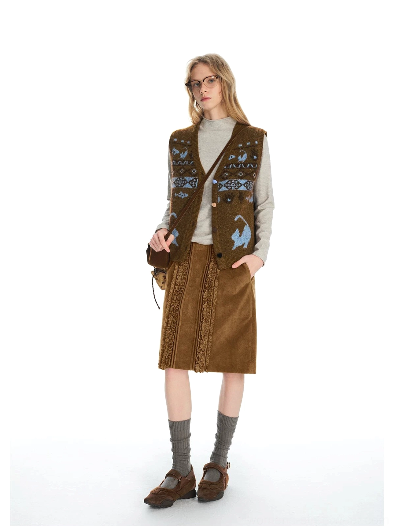 Front view of a brown corduroy lace panel midi skirt styled with a Fair Isle knit vest and vintage accessories