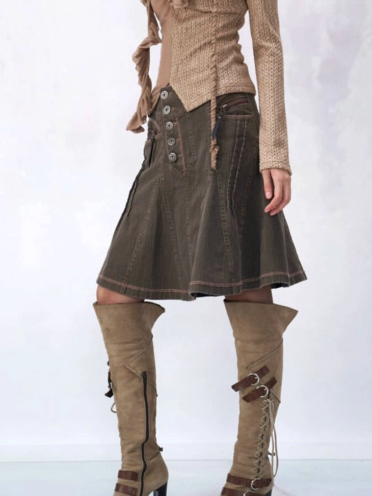 Side wearing view of brown corduroy paneled button A-line mini skirt styled with a ruffled knit top and brown knee-high buckle boots