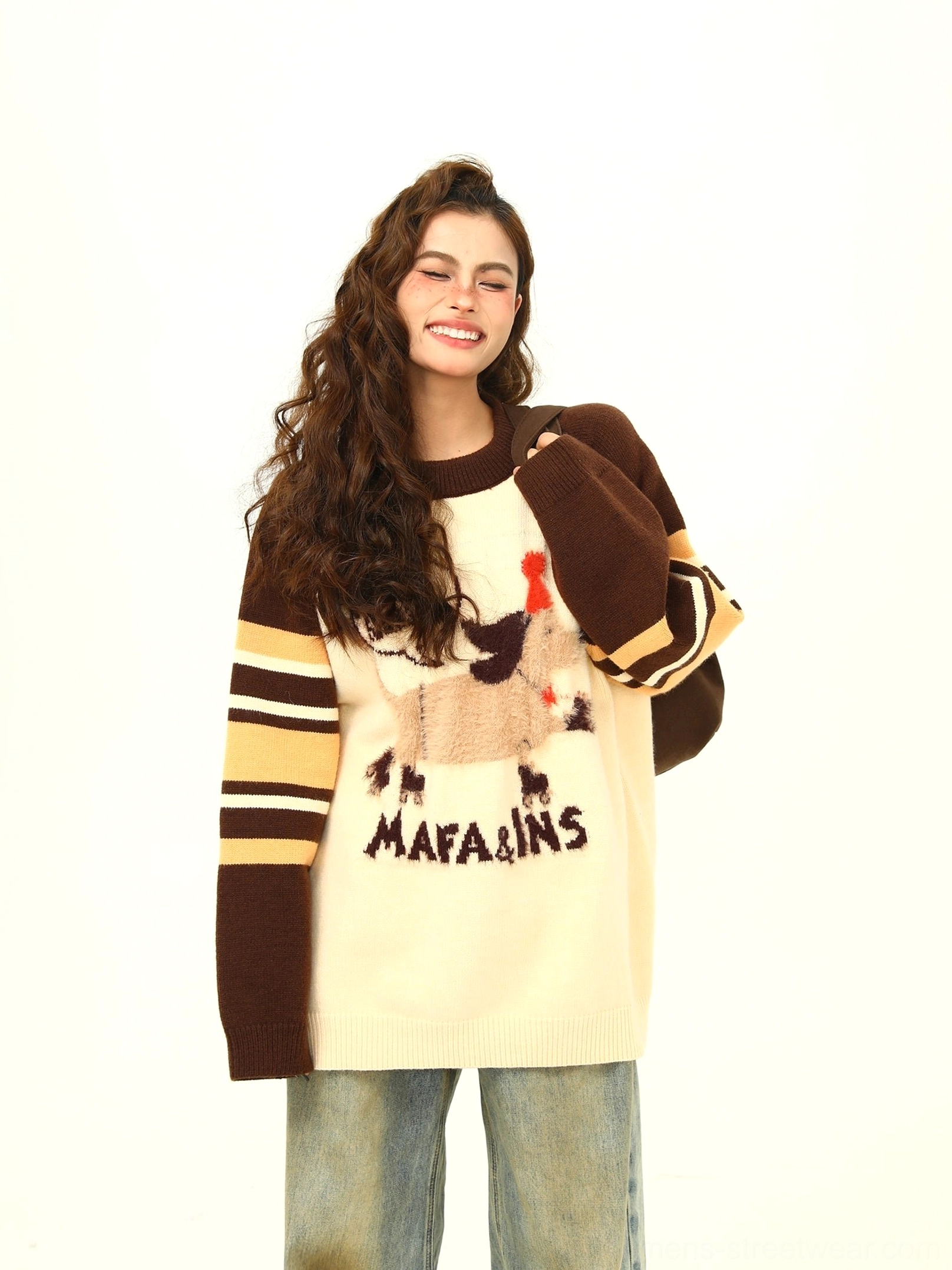 Three-quarter front view of a brown and cream cartoon dog knit sweater with striped long raglan sleeves