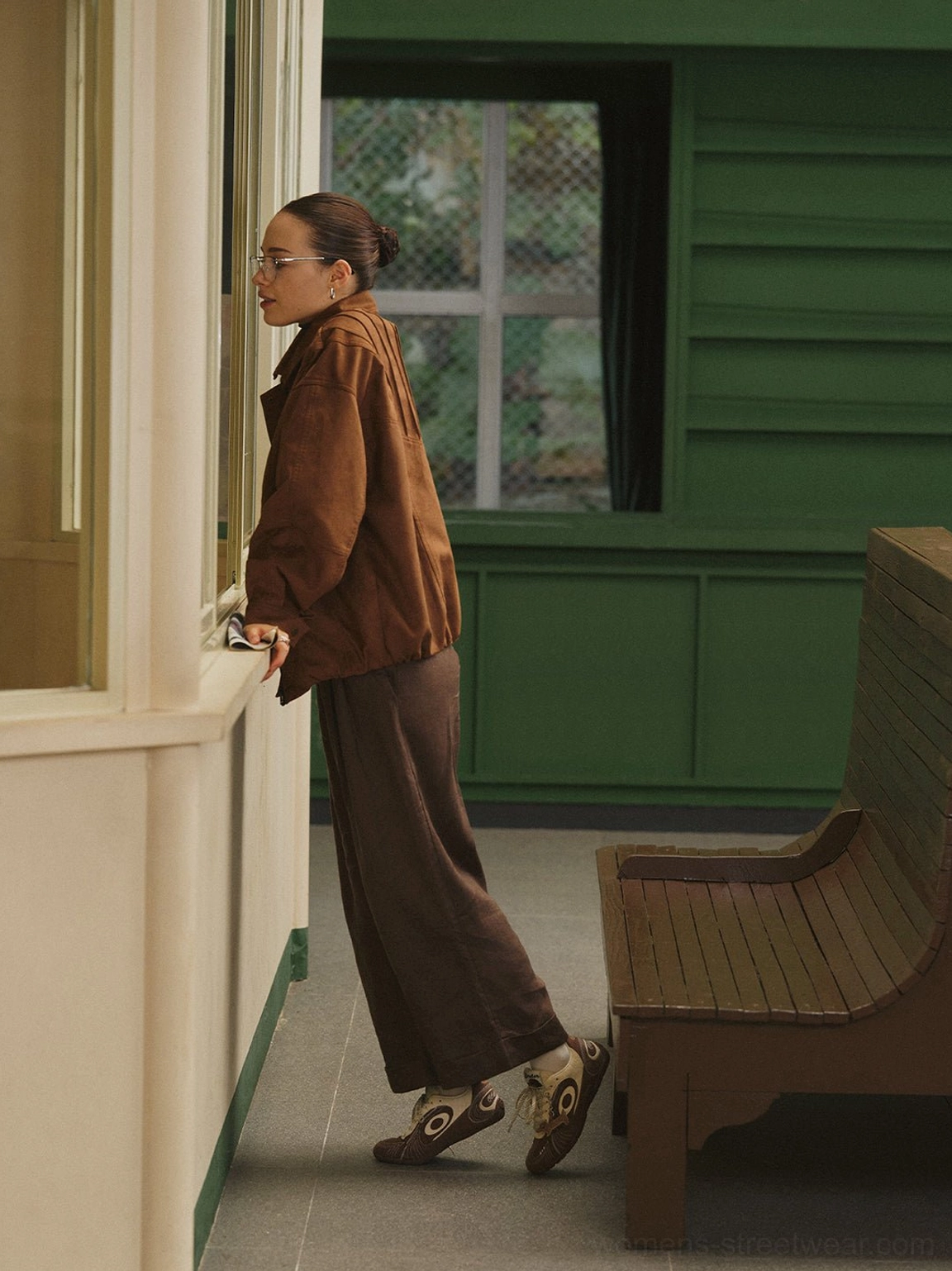 Brown and cream retro trainers with dog charm worn while walking in a relaxed vintage streetwear outfit