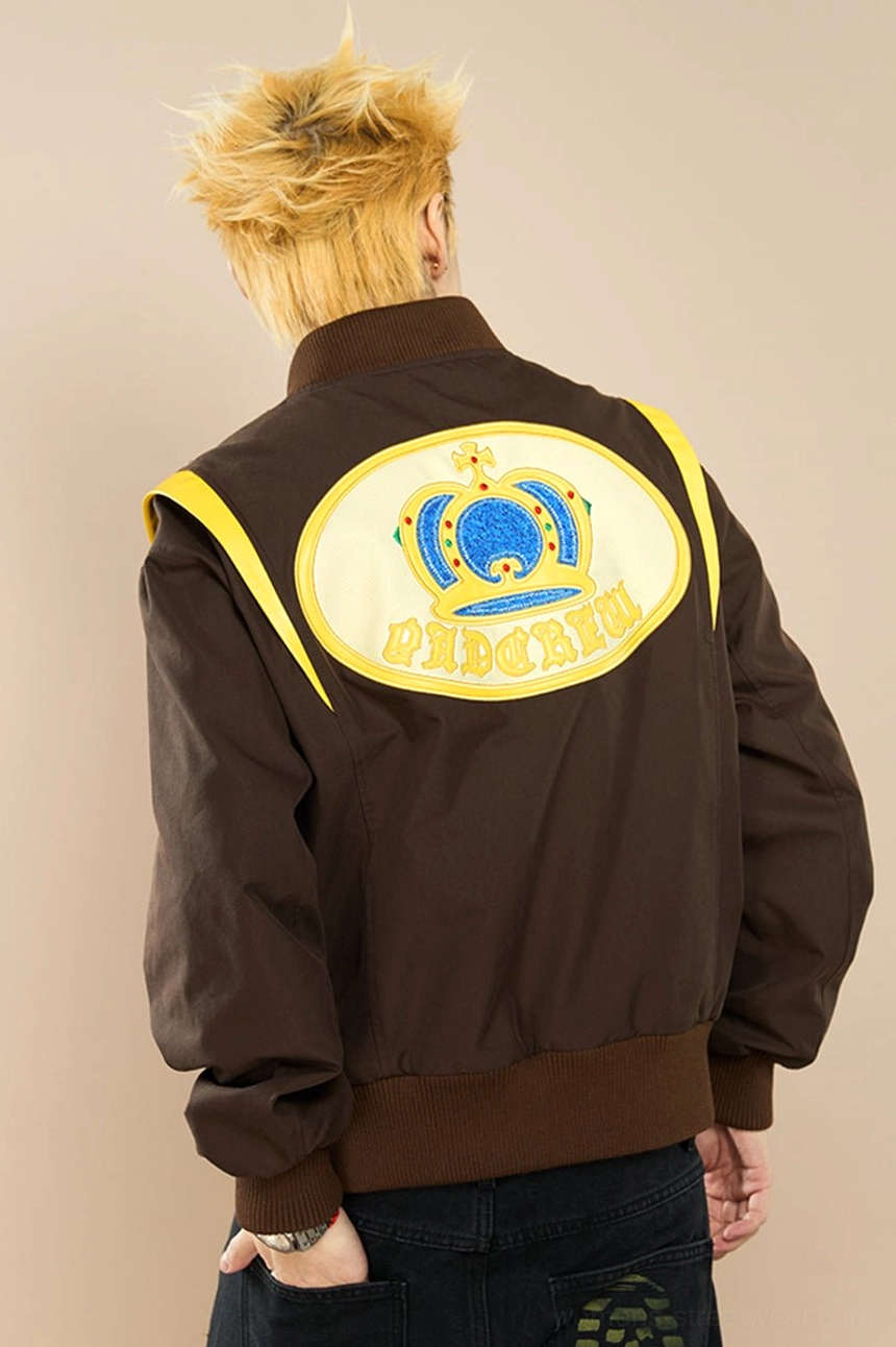 Back three quarter view of brown crown embroidered baseball jacket showing royal crown embroidery and ribbed hem