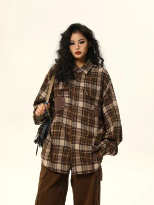 Brown distressed patchwork oversized plaid flannel shirt front three-quarter view styled with brown cargo pants and crossbody bag