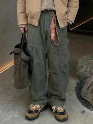 Brown distressed suede trail runner sneakers styled with green cargo pants and khaki streetwear outfit