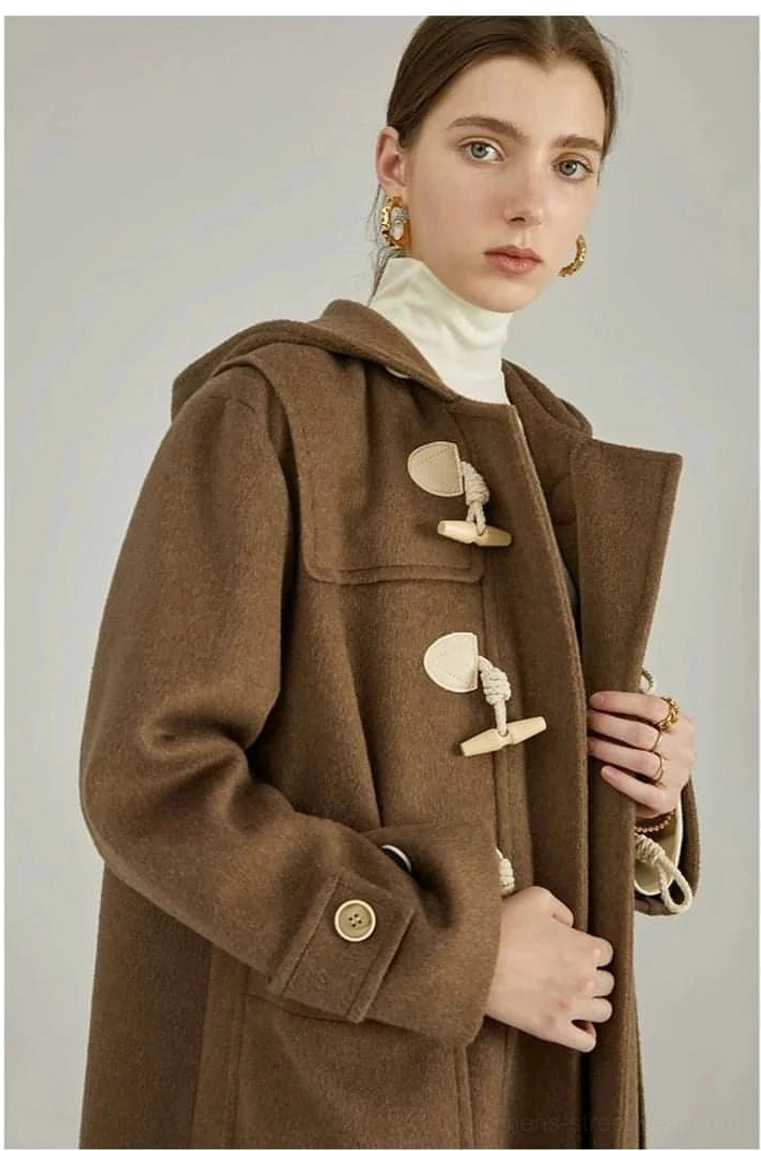 Dark brown wool duffle coat close-up half body front view horn toggles metal cuff buttons visible