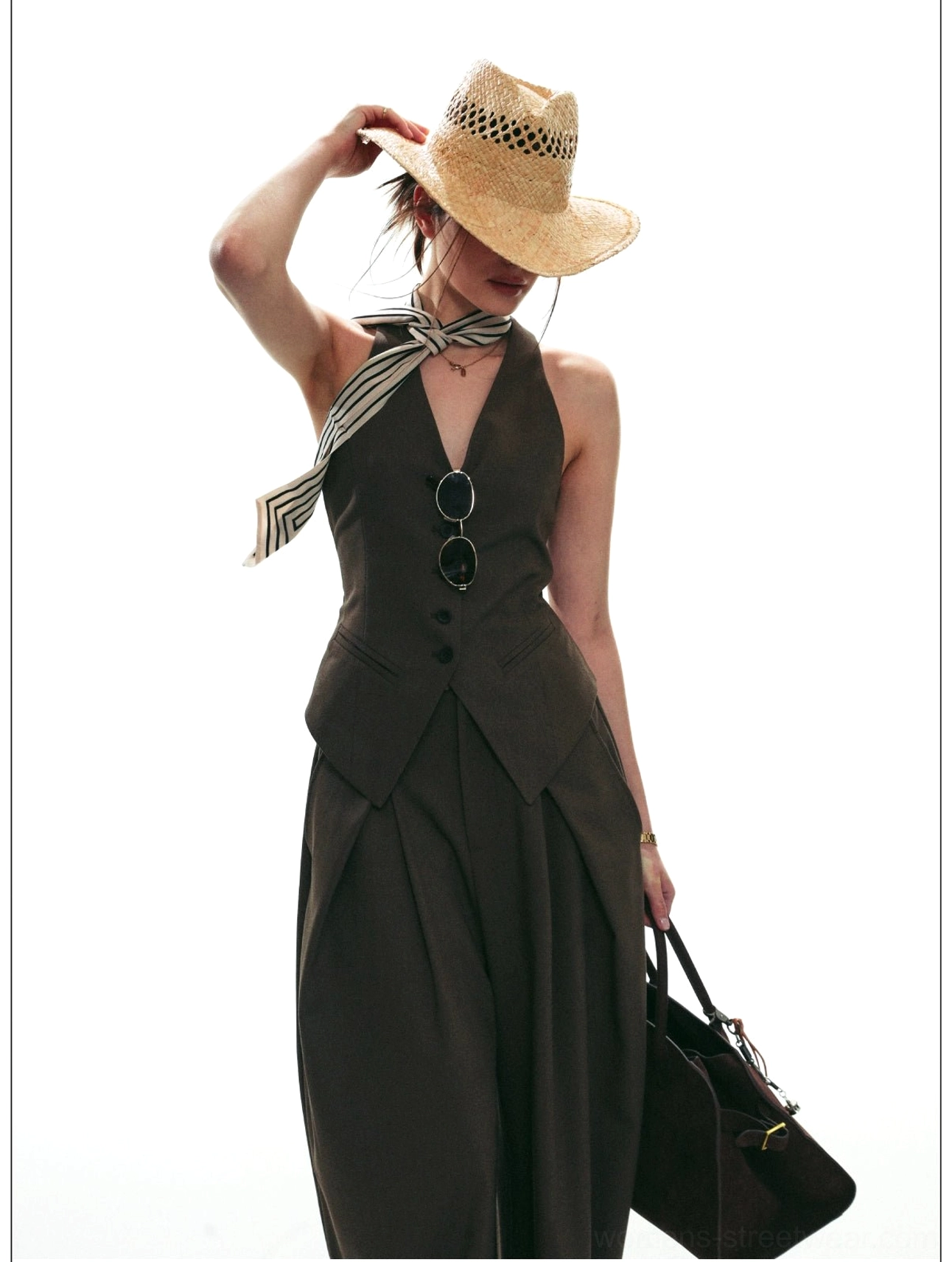 Brown fitted halter waistcoat and matching wide-leg trousers styled with a striped scarf and leather tote