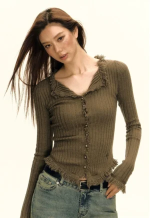 Three-quarter view of brown frayed ribbed button-up cardigan with fitted sleeves and distressed trim details