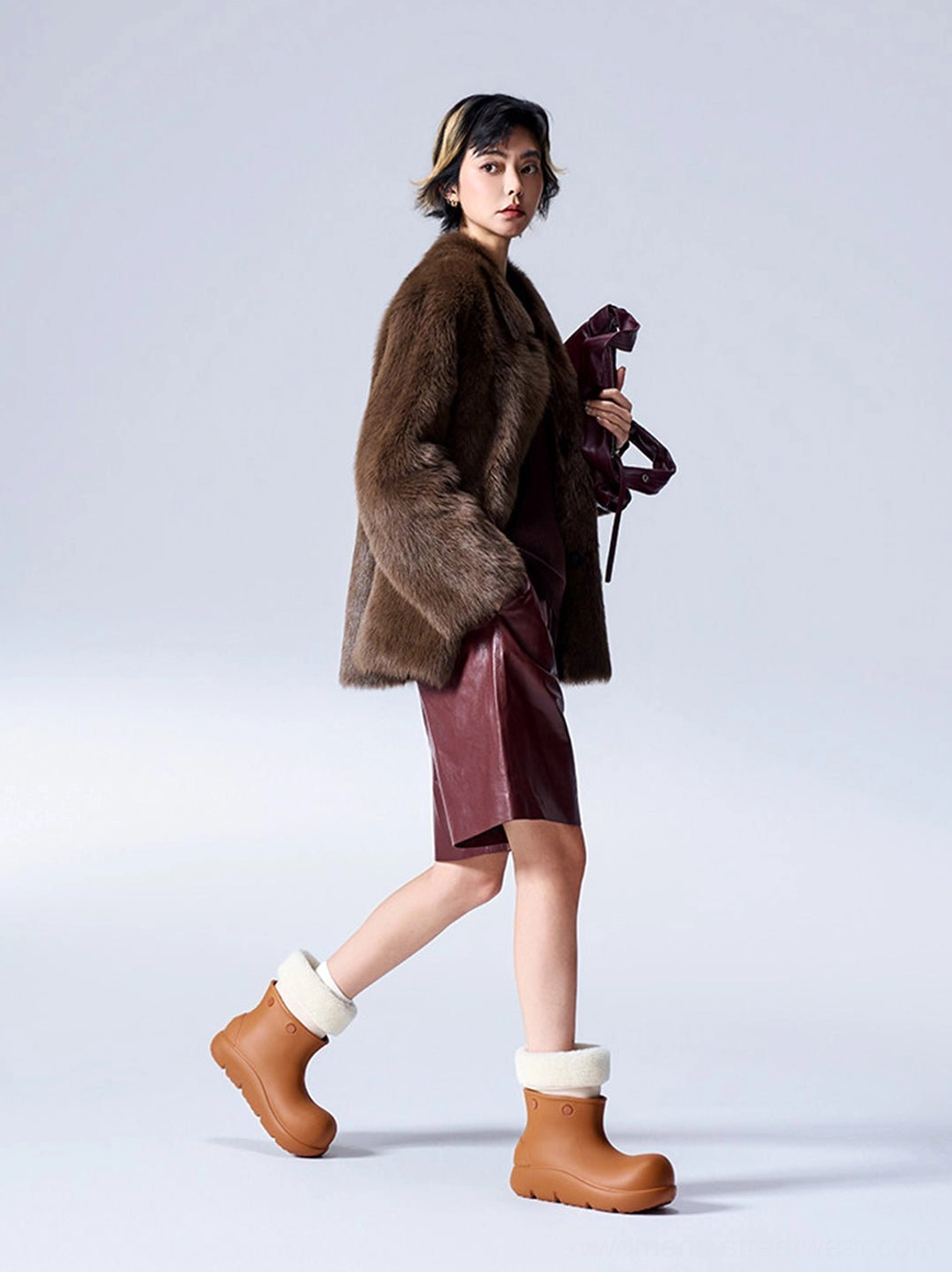 Full body streetwear outfit featuring brown fur-lined chunky platform ankle boots with burgundy skirt and brown fur coat